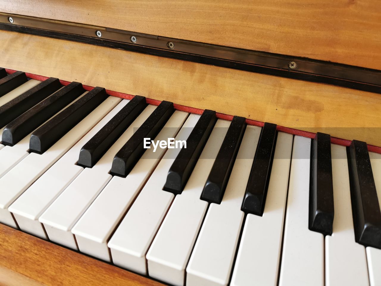 HIGH ANGLE VIEW OF PIANO KEYS ON WOOD