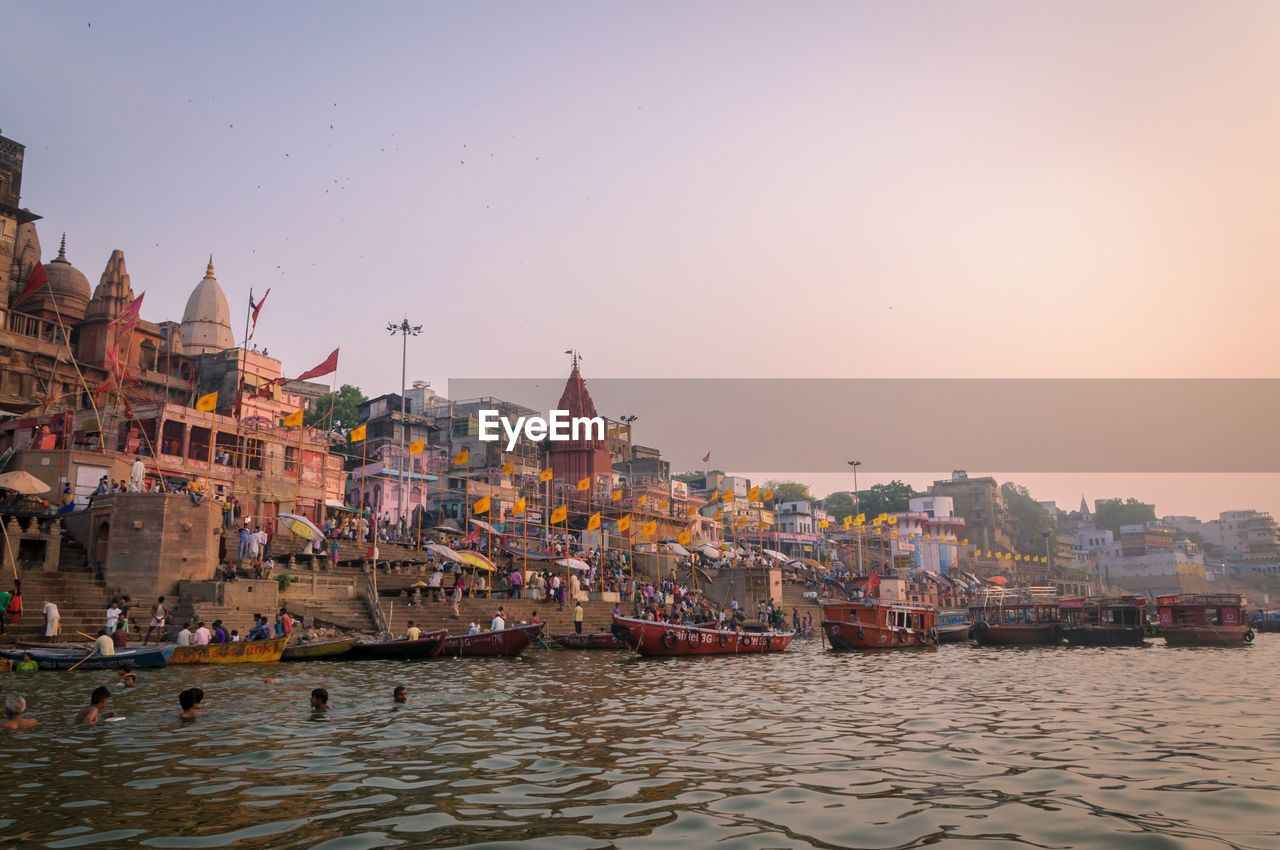 Scenic view of boats in river next to temple against clear sky