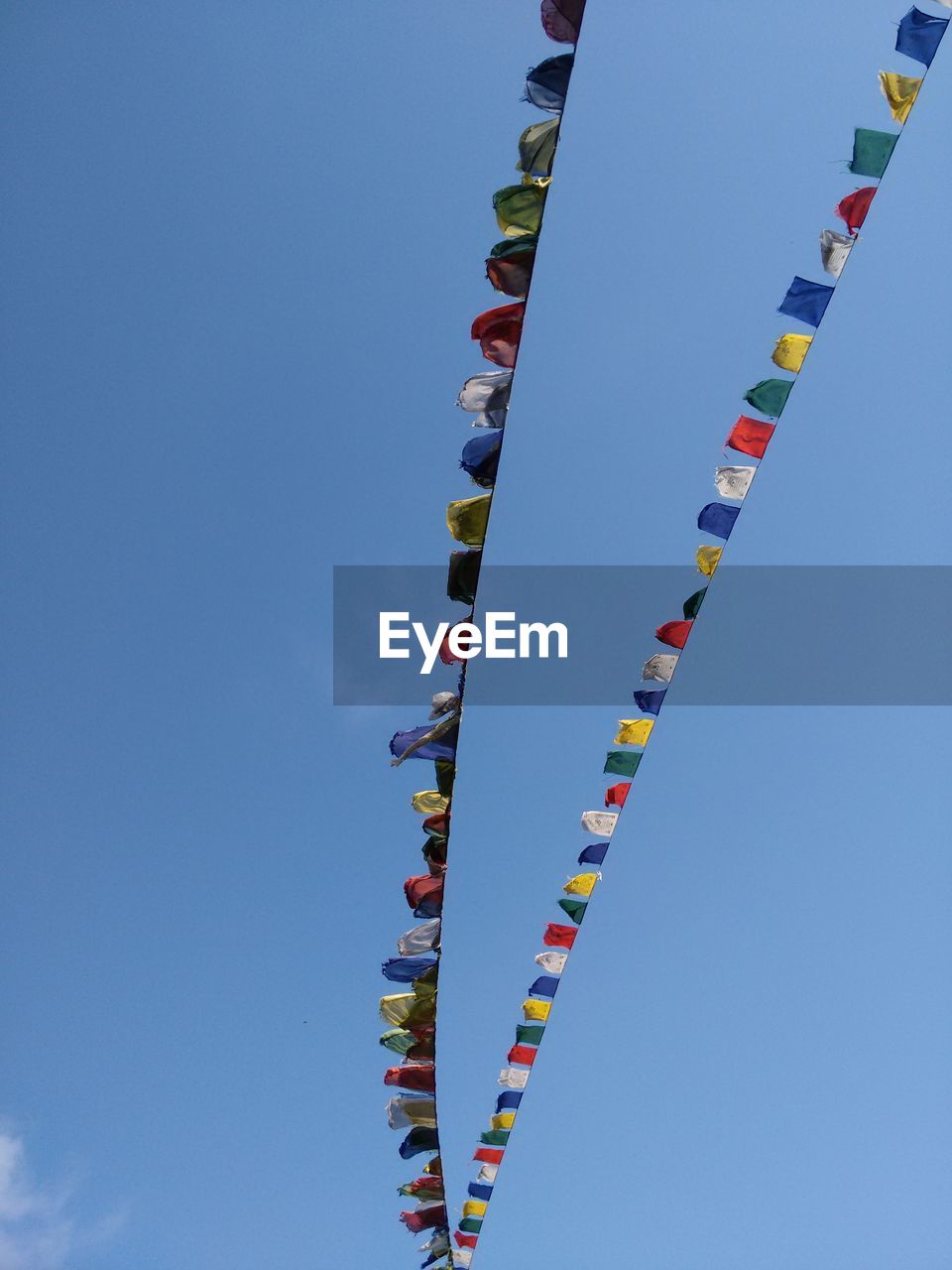 Low angle view of prayer flags against sky on sunny day