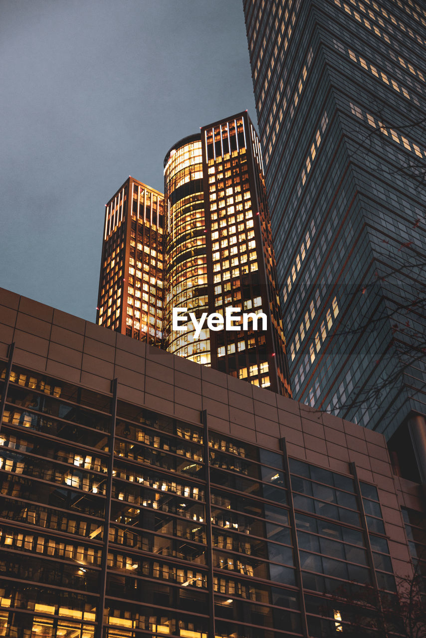 Low angle view of illuminated buildings against sky at dusk