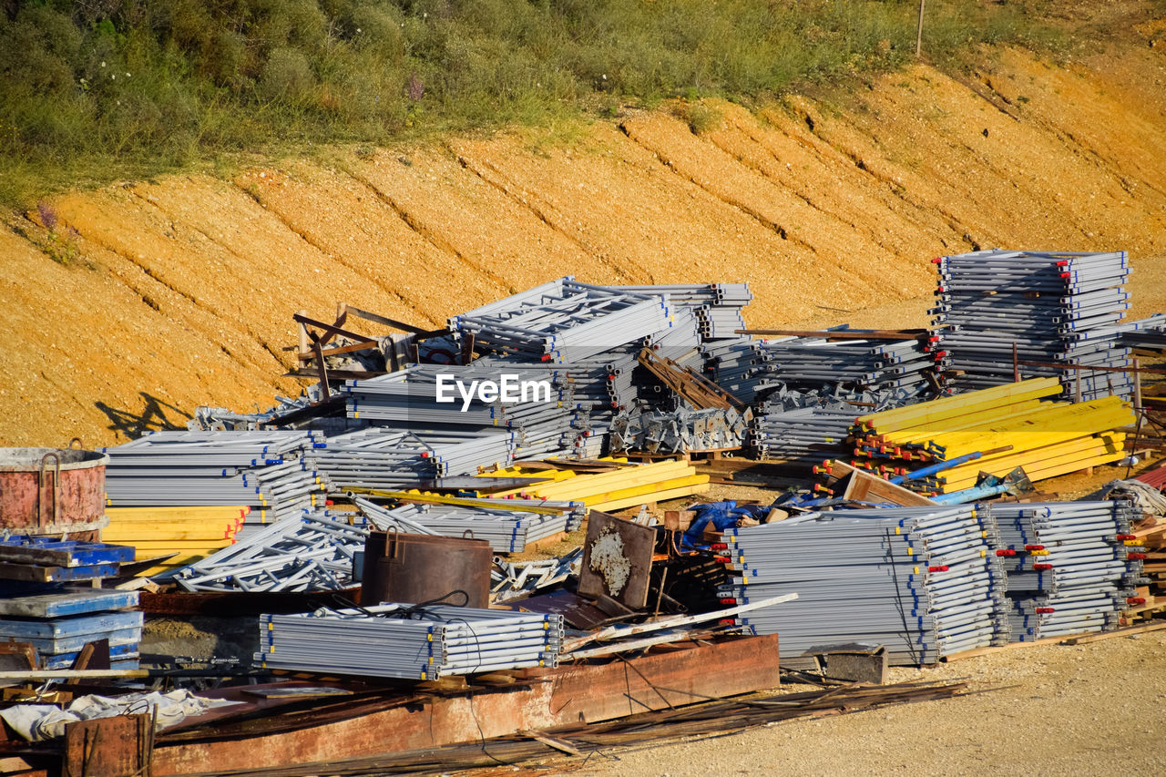 HIGH ANGLE VIEW OF CONSTRUCTION SITE ON FIELD BY ROAD