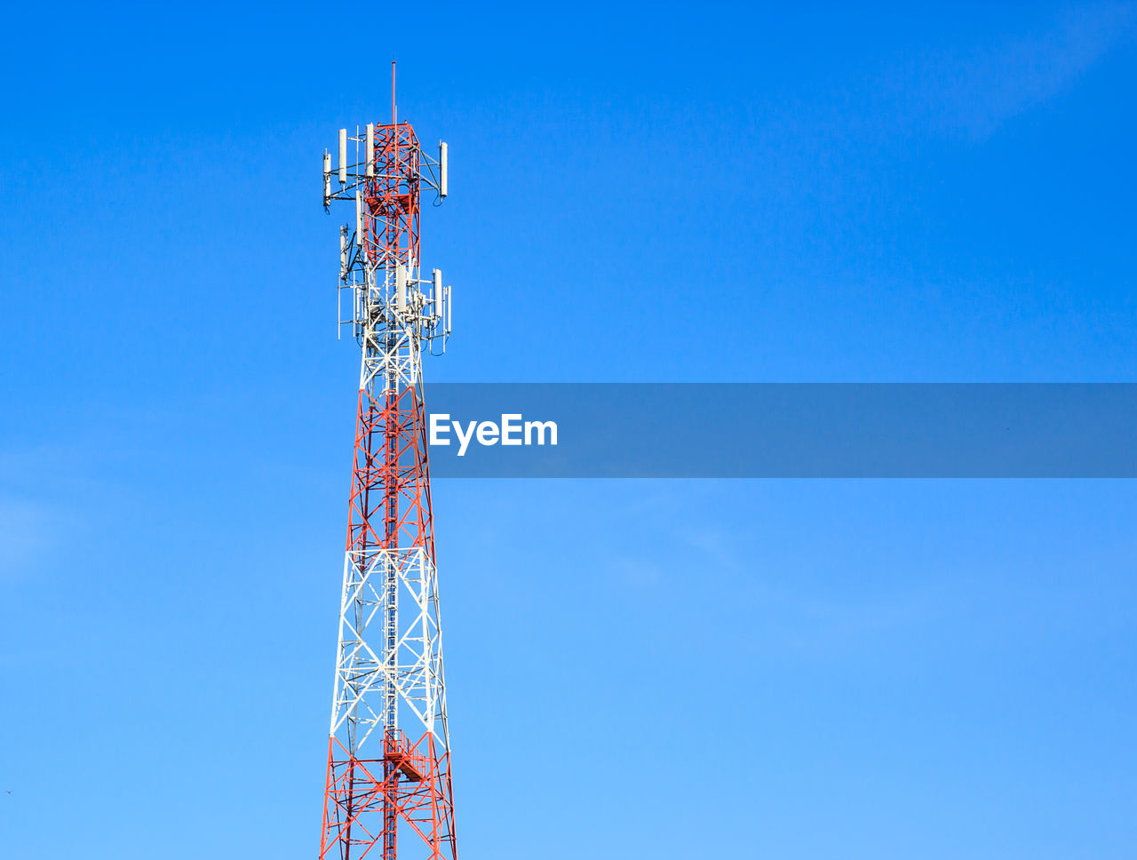 Low angle view of communications tower against blue sky