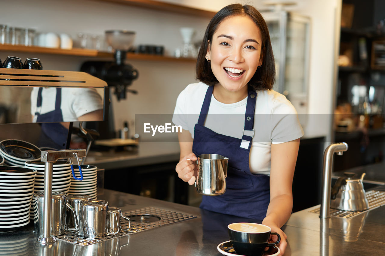 portrait of young woman using mobile phone in cafe