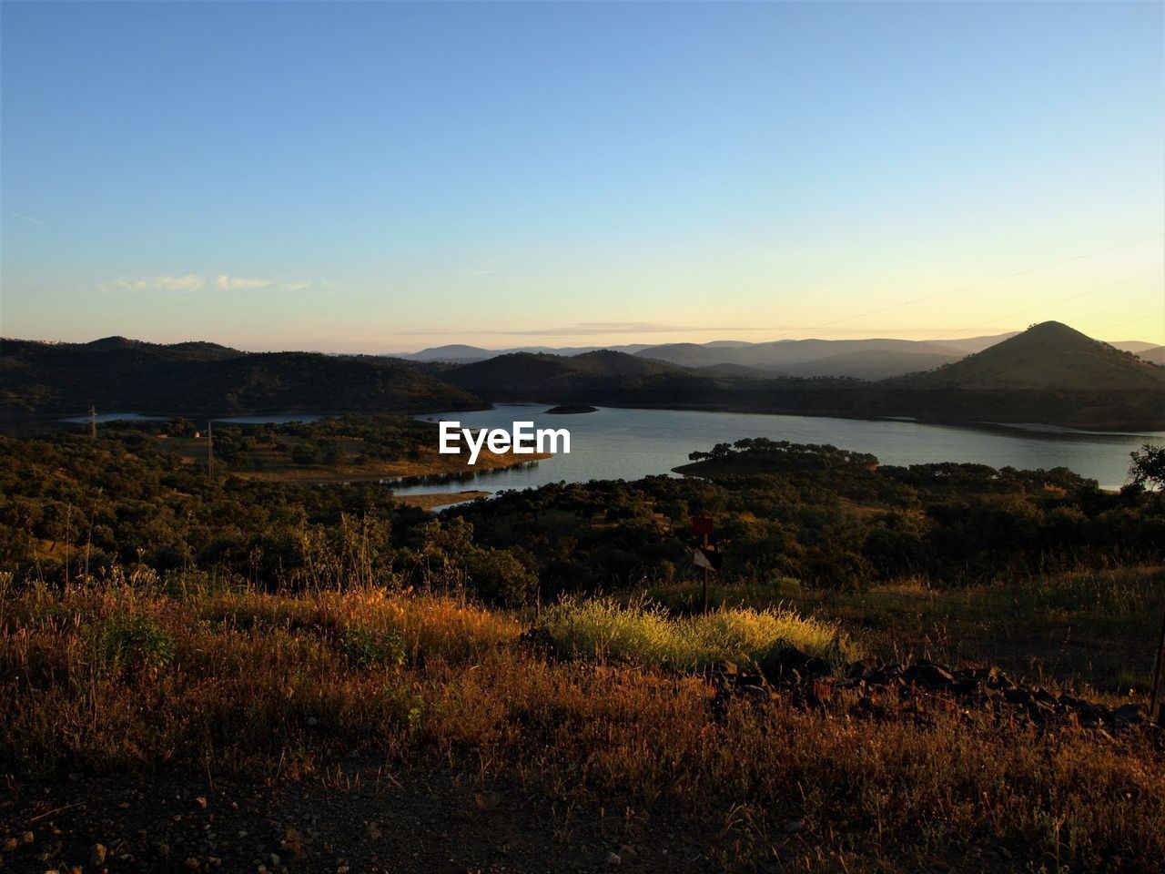 Scenic view of lake and mountains against clear sky