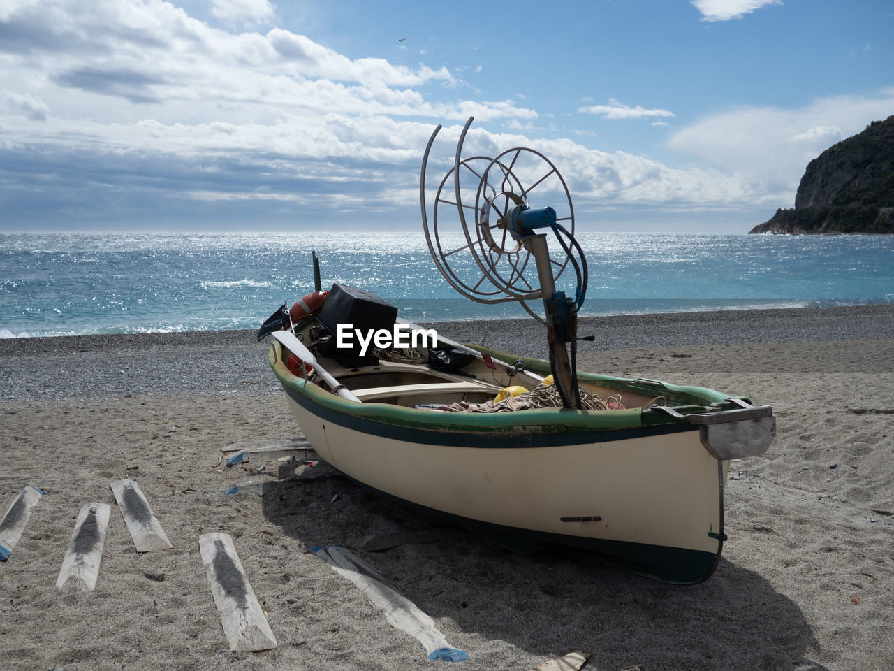 Boat moored on beach against sky