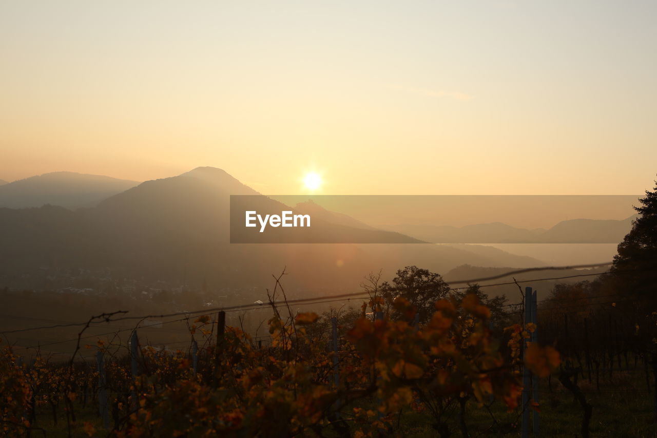 SCENIC VIEW OF MOUNTAINS AGAINST ORANGE SKY