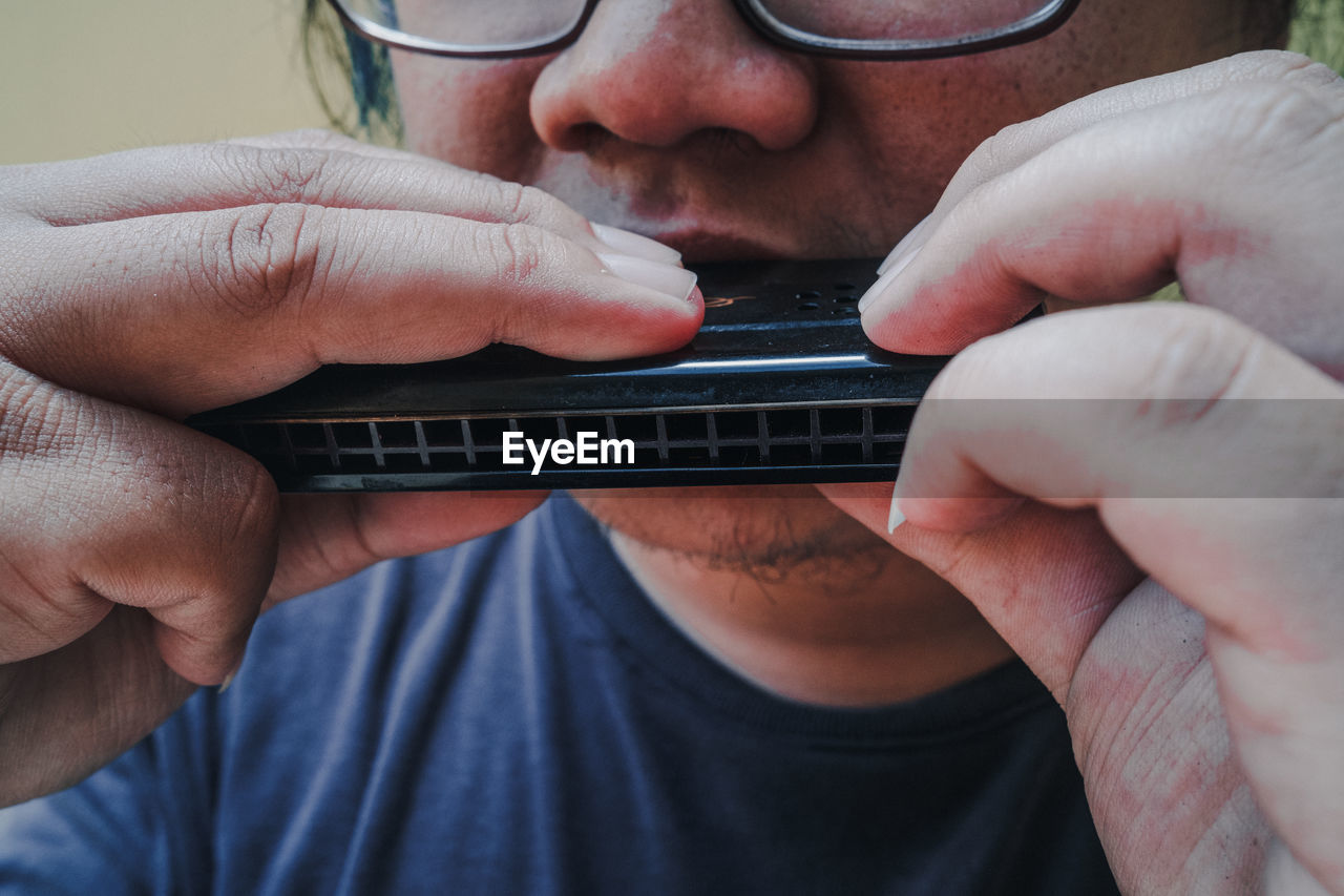 Close-up of man playing harmonica