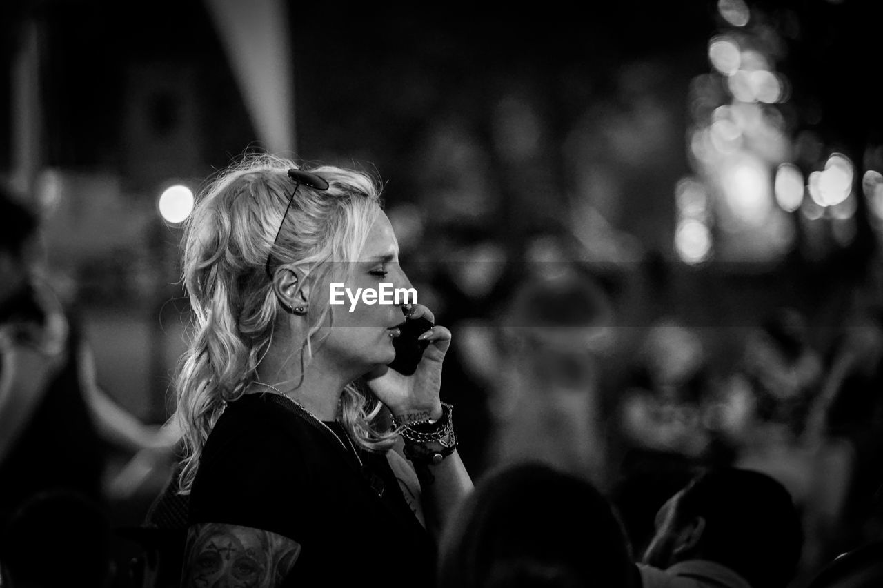 SIDE VIEW OF WOMAN LOOKING AT TREE