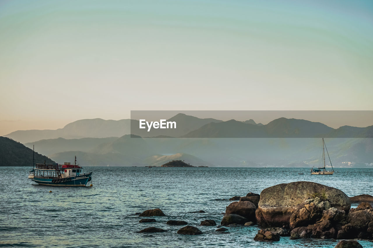 FISHING BOATS IN SEA AGAINST CLEAR SKY