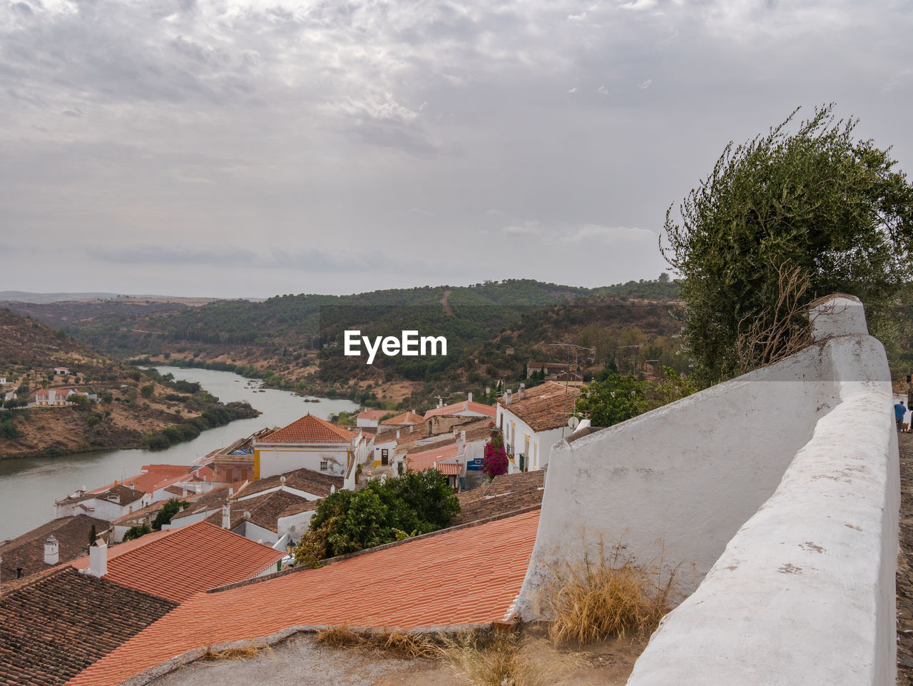 HIGH ANGLE VIEW OF TOWNSCAPE BY TREE AGAINST SKY