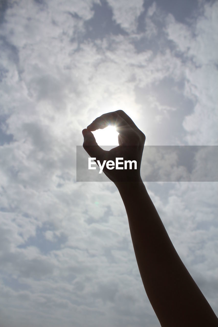 Low angle view of hand against sky