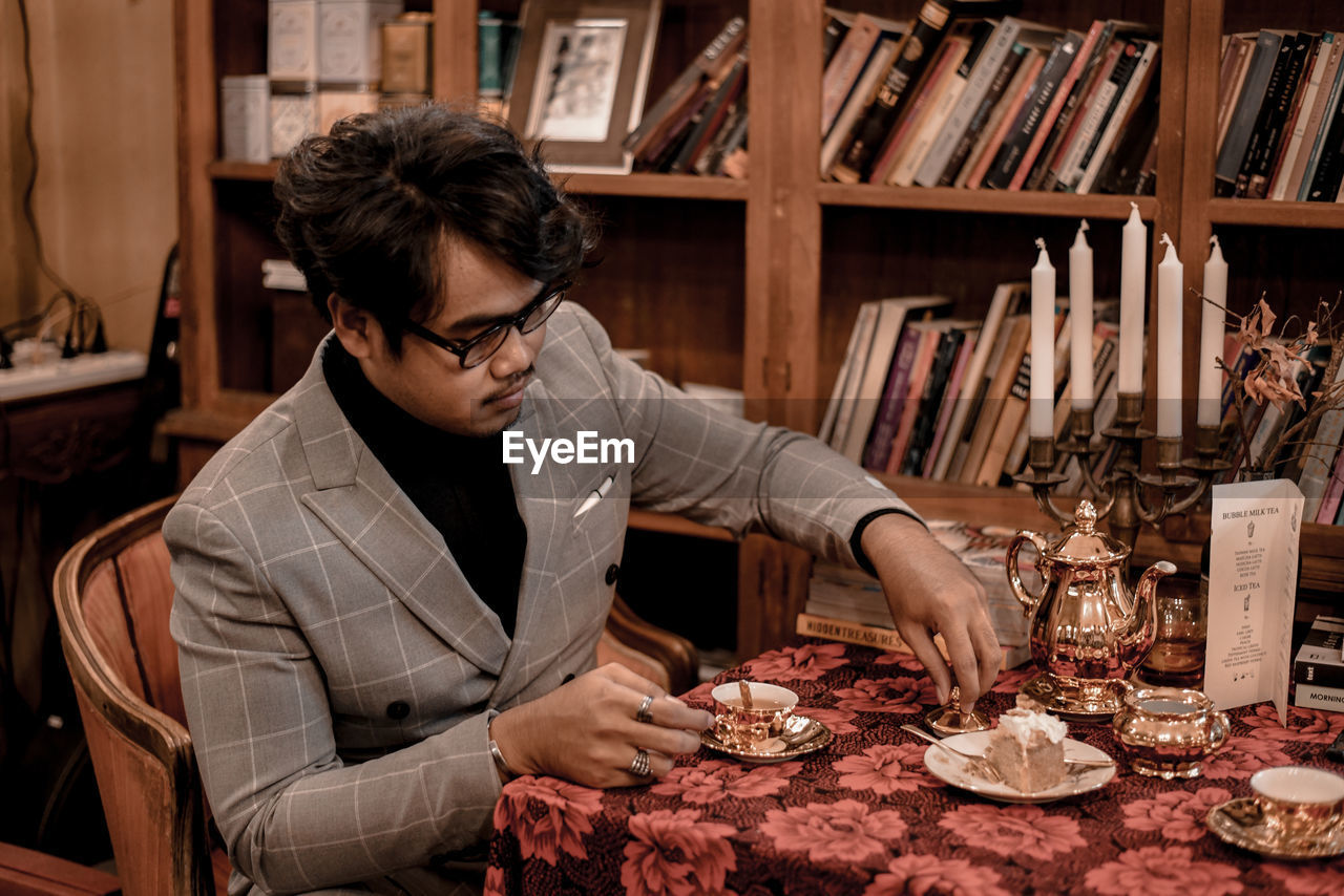 Young man having breakfast while sitting on table