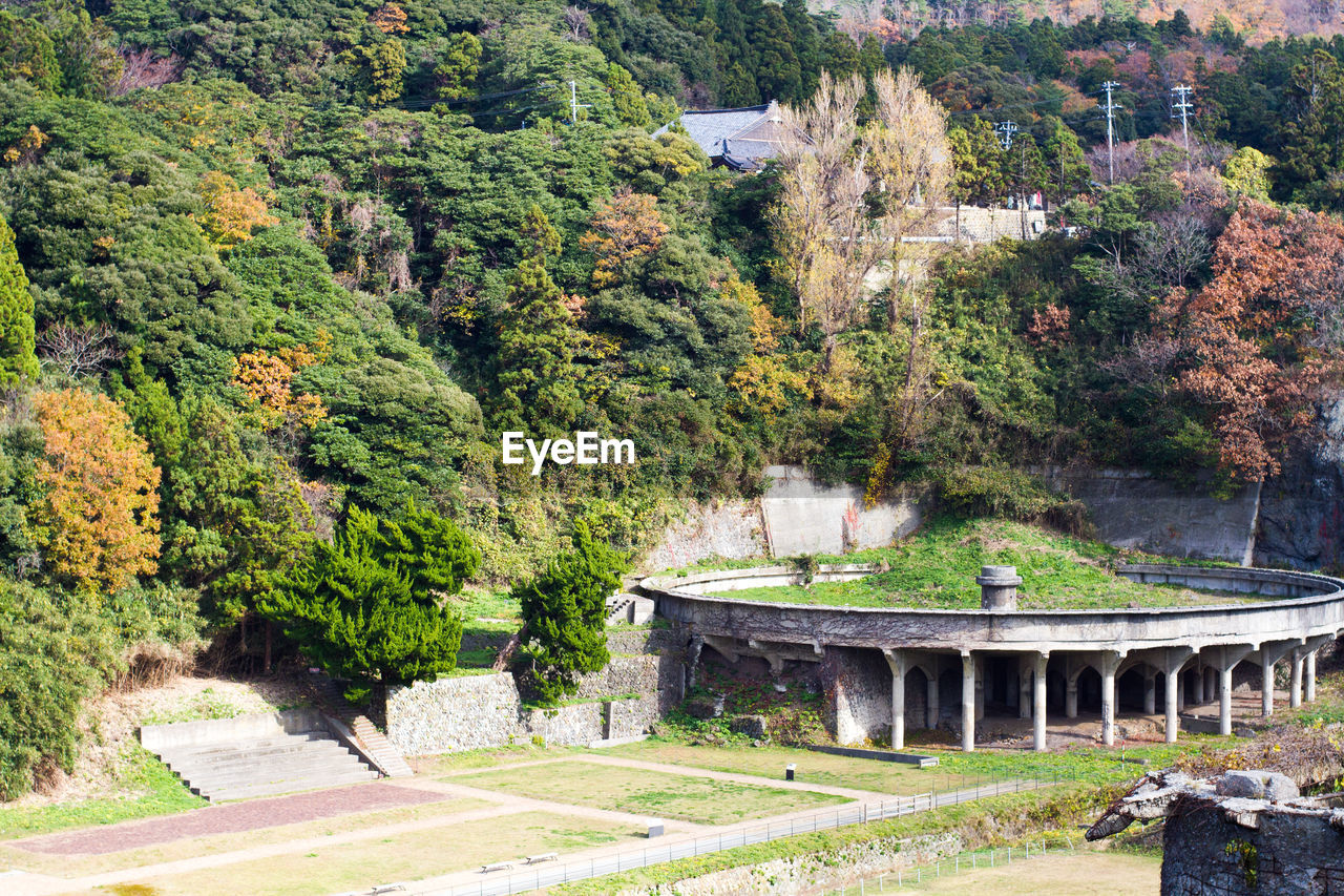 High angle view of old ruin building by trees on field