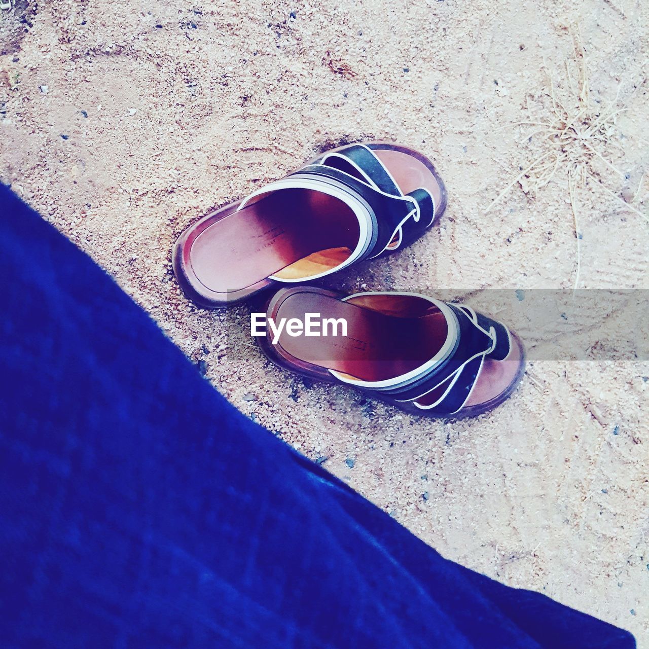 CLOSE-UP OF SHOES ON SAND