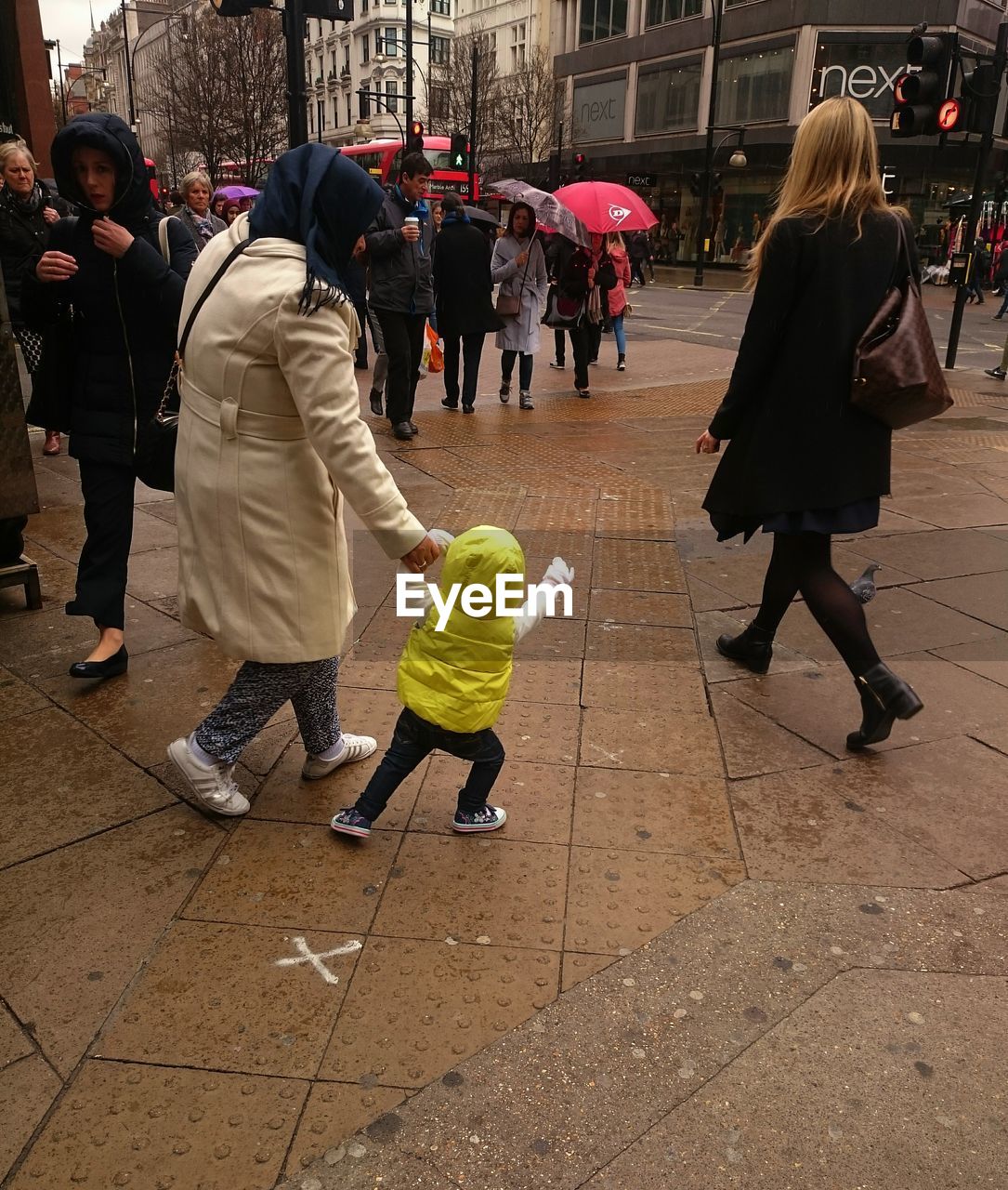 REAR VIEW OF PEOPLE WALKING ON STREET