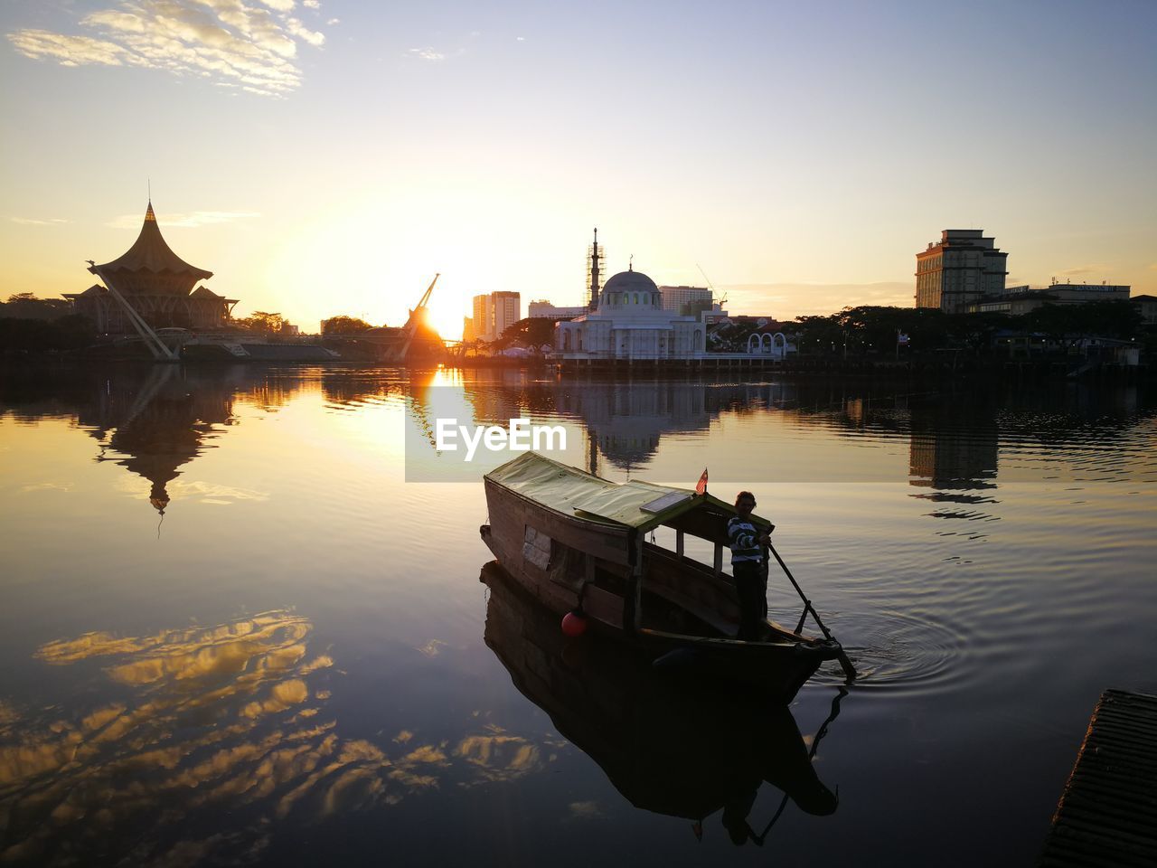 BOAT IN LAKE AGAINST BUILDINGS IN CITY