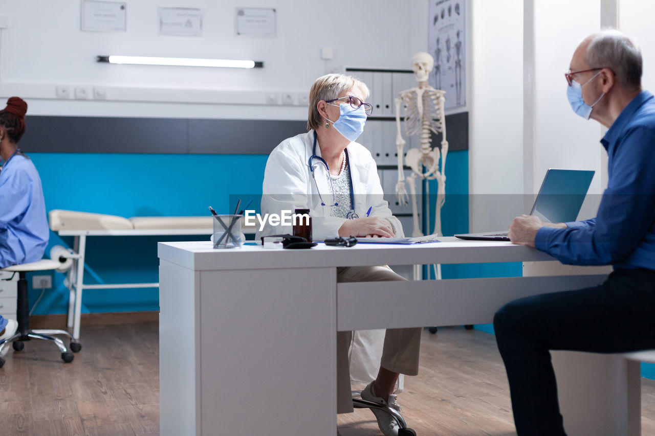 Doctor wearing mask examining patient