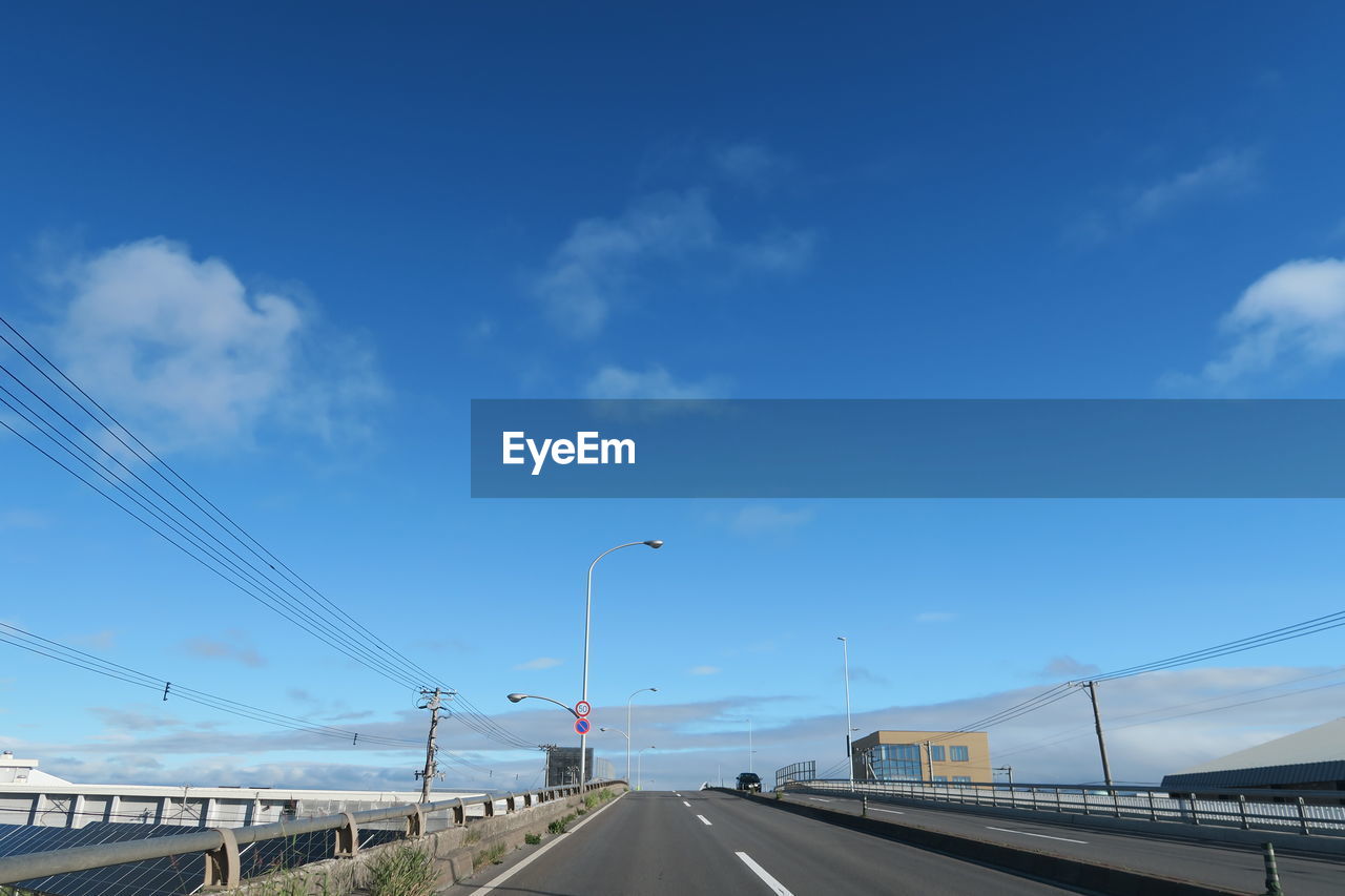 Bridge over highway against blue sky