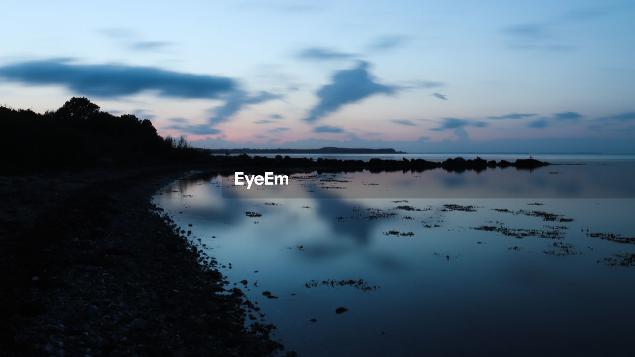 Scenic view of lake against sky at sunset