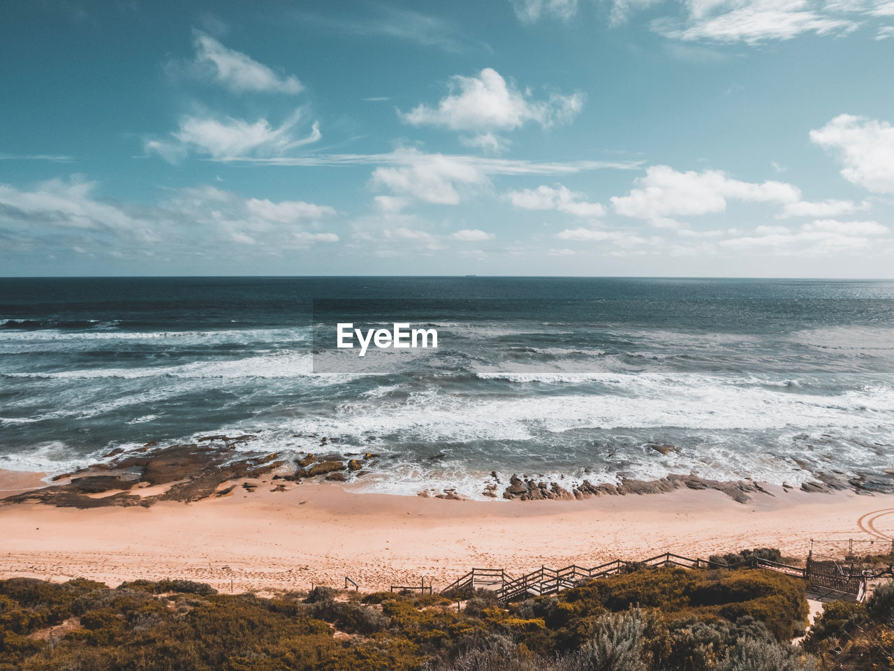 Scenic view of ocean and waves against sky