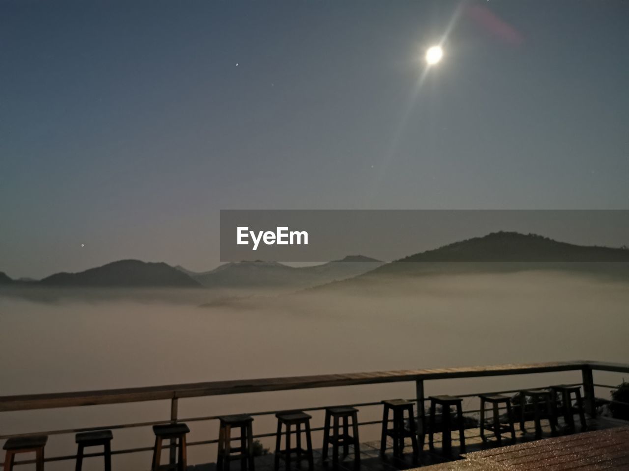 sky, water, mountain, scenics - nature, moon, horizon, nature, beauty in nature, dawn, morning, railing, tranquility, night, tranquil scene, lake, mountain range, astronomical object, pier, no people, environment, architecture, outdoors, bridge, landscape, silhouette, full moon, travel destinations, land, moonlight, astronomy, idyllic, travel, built structure, fog, beach, wood, star