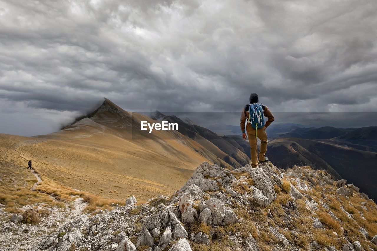 Man standing on mountain against sky