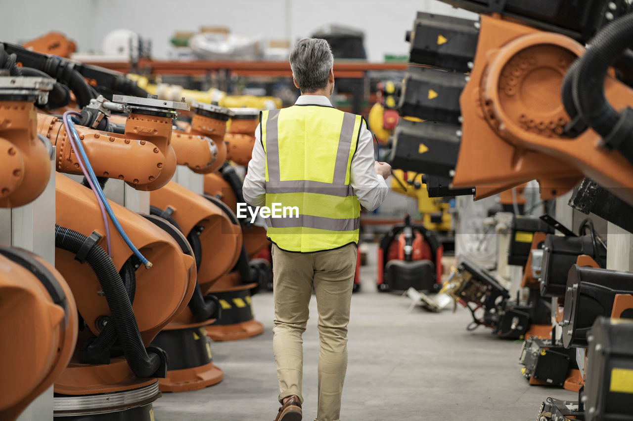 Engineer in reflective clothing walking in factory