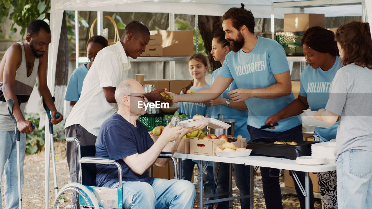 group of friends using digital tablet while sitting at restaurant