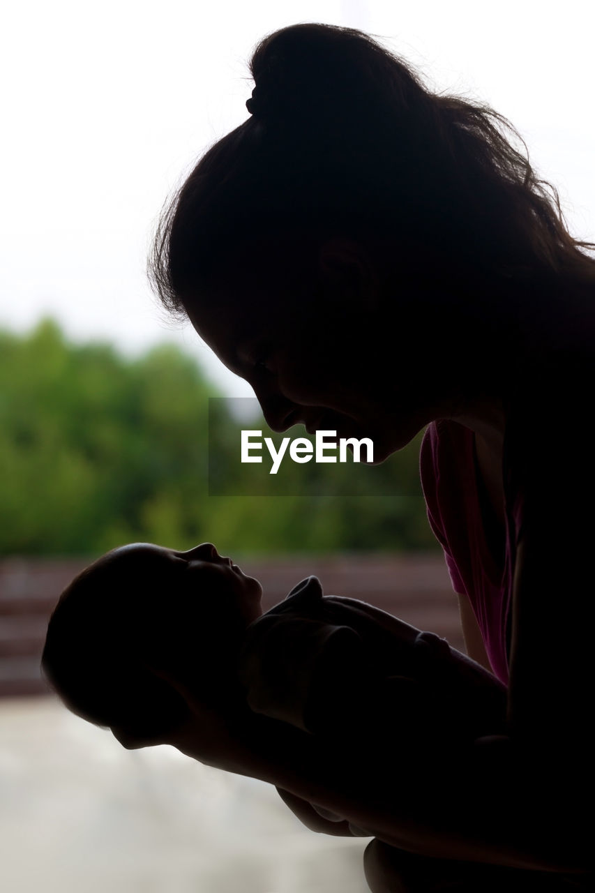 Close-up of mother holding baby while standing outdoors