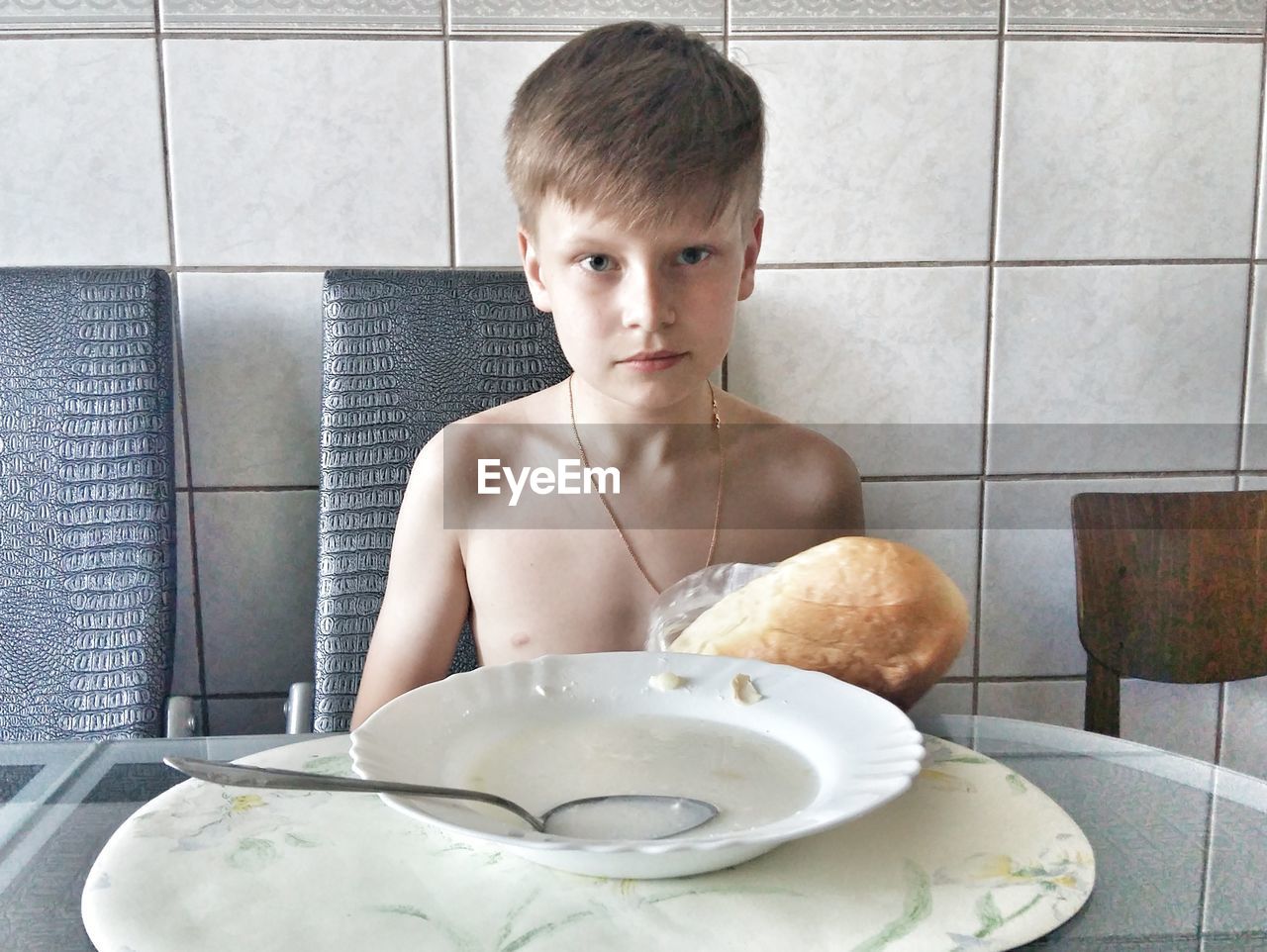 PORTRAIT OF BOY SITTING AT TABLE