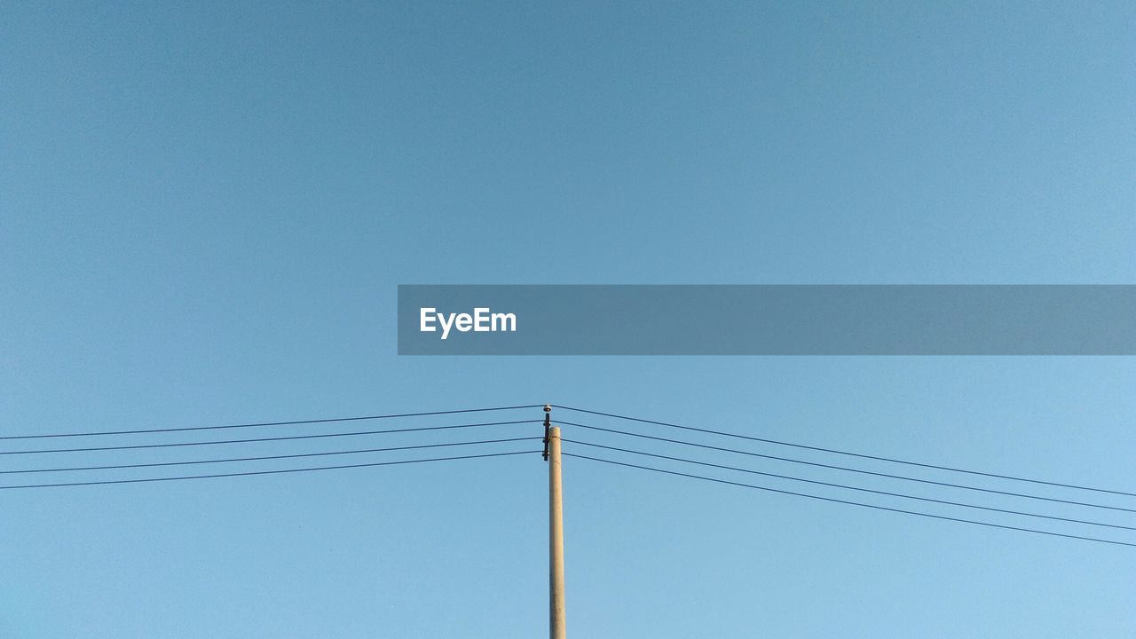 LOW ANGLE VIEW OF ELECTRICITY PYLON AGAINST CLEAR SKY