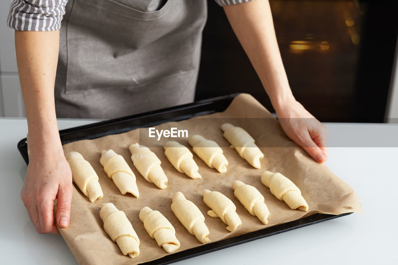 A woman is in the kitchen baking bagels with jam. sweet pastry with your own hands.