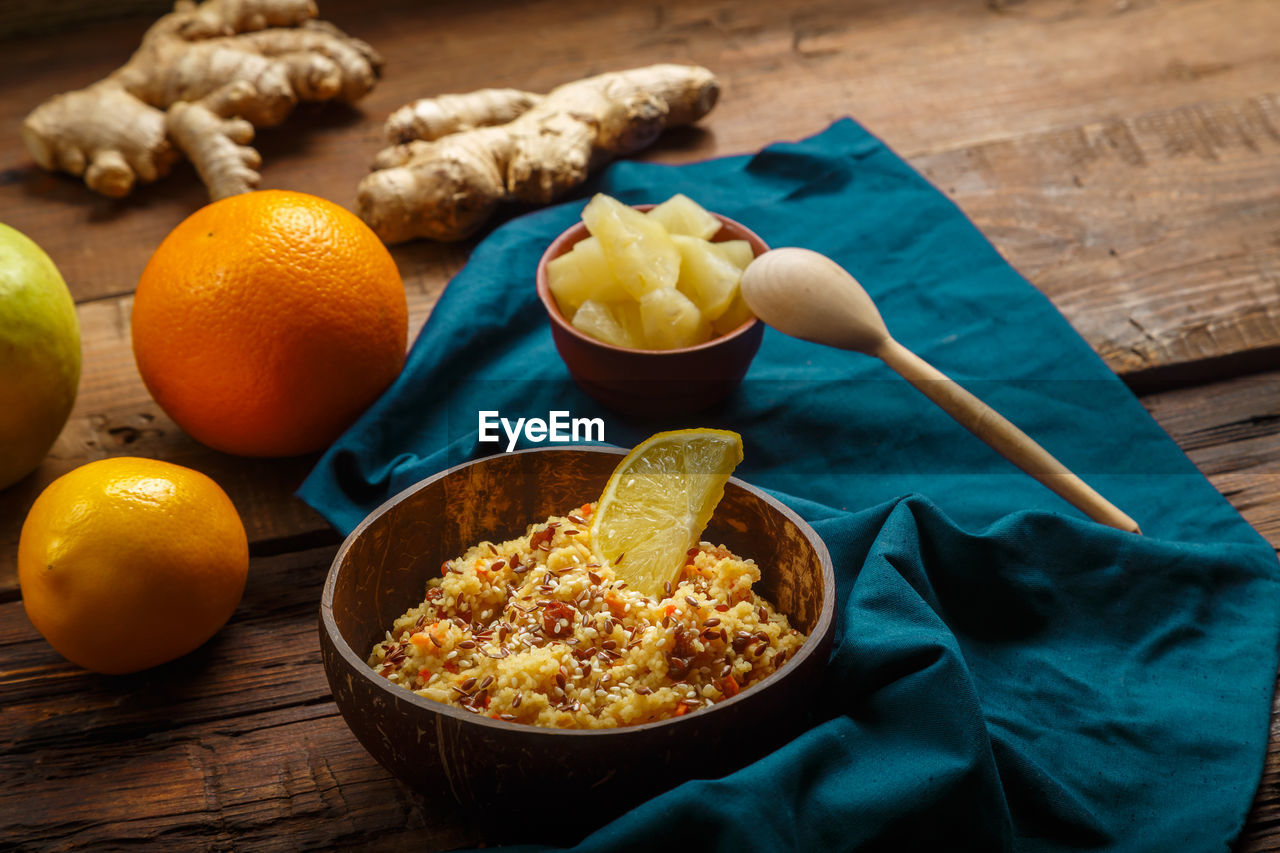 Couscous masfouf with dried fruits and nuts in a plate on a blue napkin on a wooden table 