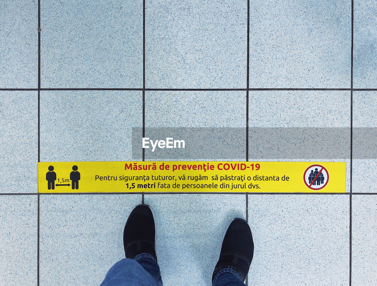Low section of man walking by information sign on floor