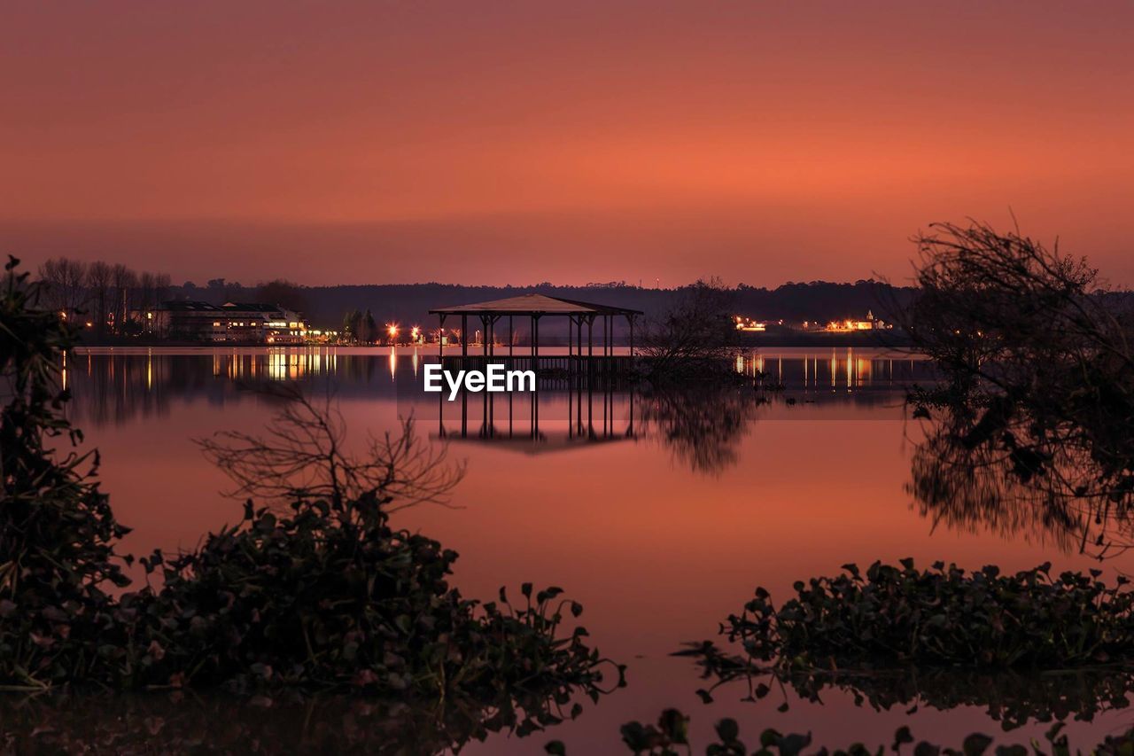 Scenic view of river against sky at dusk