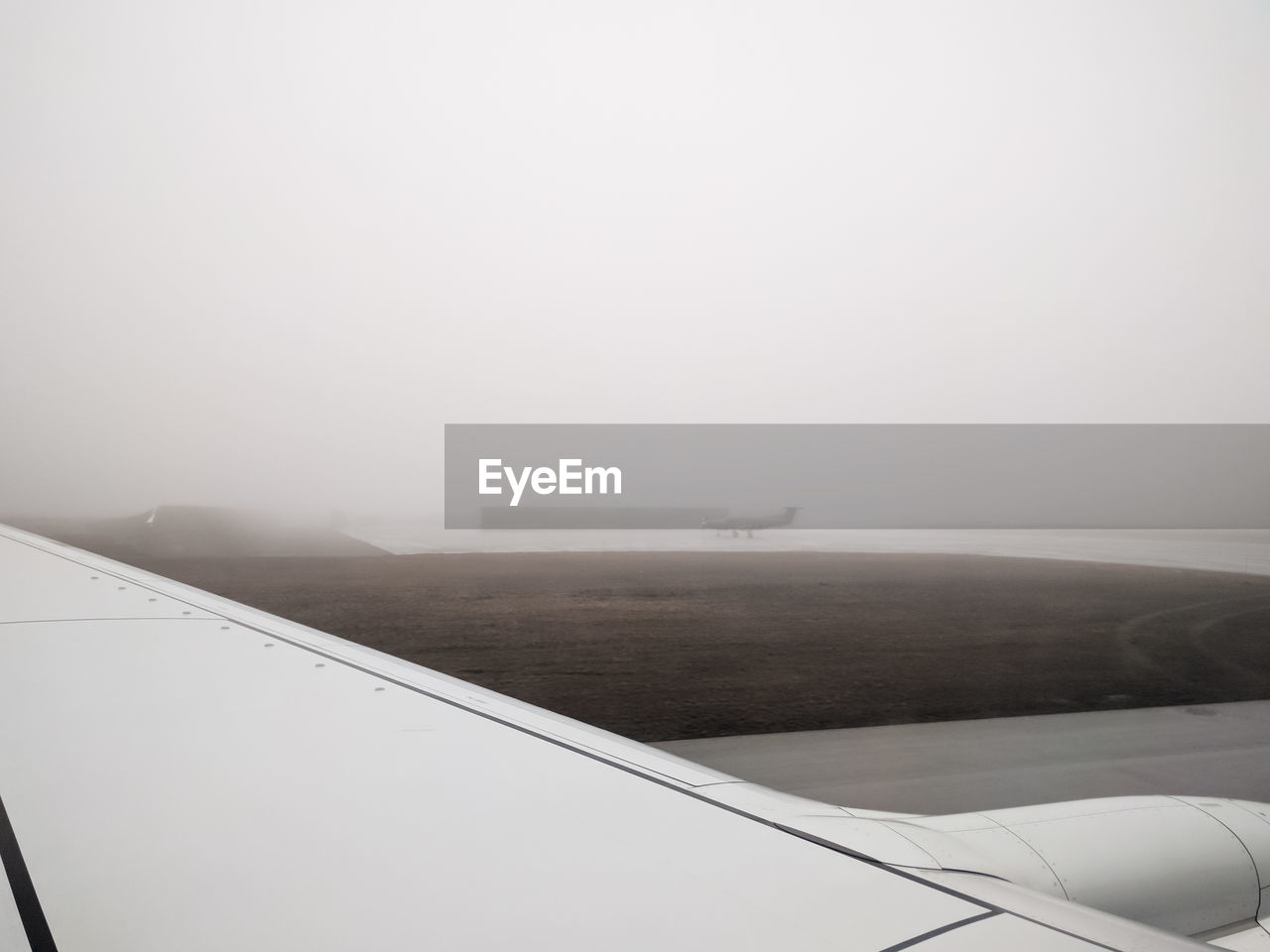 Cropped image of airplane against sky during foggy weather