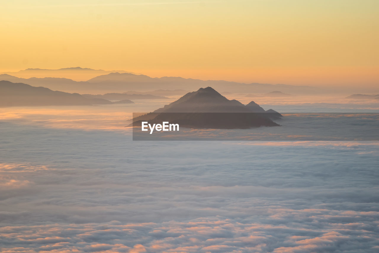 SCENIC VIEW OF CLOUDS OVER MOUNTAIN AGAINST SKY DURING SUNSET