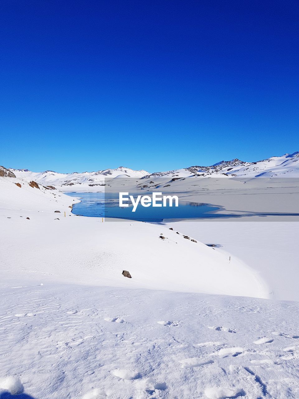 SCENIC VIEW OF SNOW COVERED LANDSCAPE AGAINST CLEAR BLUE SKY