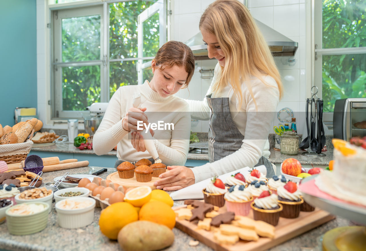 Mother and daughter are happily working together in baking.