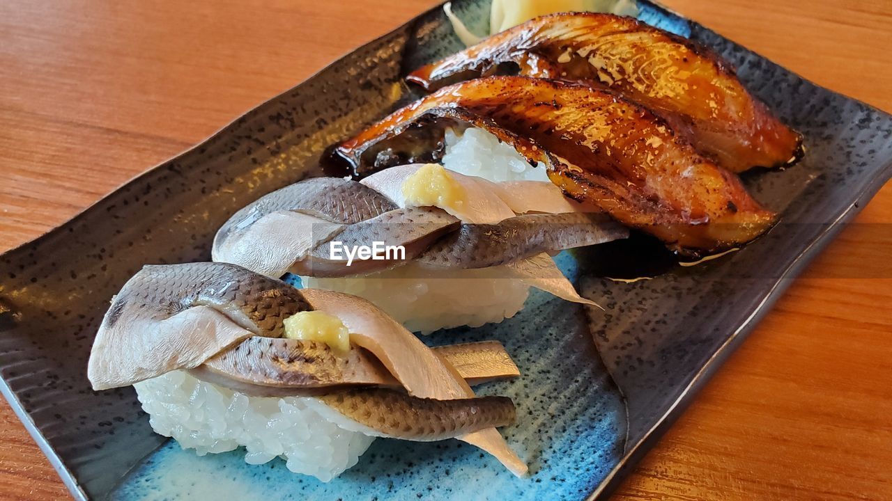 food and drink, food, freshness, wood, table, dish, indoors, healthy eating, high angle view, no people, cutting board, still life, meal, cuisine, wellbeing, meat, produce, close-up, seafood, slice, fish, plate