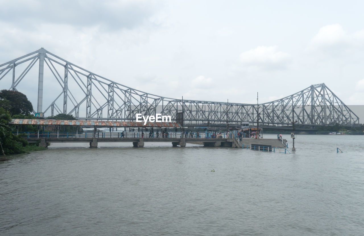 architecture, bridge, built structure, water, sky, transportation, cloud, travel destinations, city, nature, travel, river, tourism, engineering, cable-stayed bridge, cantilever bridge, building exterior, suspension bridge, day, outdoors, cityscape, waterfront, arch bridge, building, construction industry, industry, overcast, business finance and industry, scenics - nature, environment, mode of transportation, beauty in nature, landscape, business
