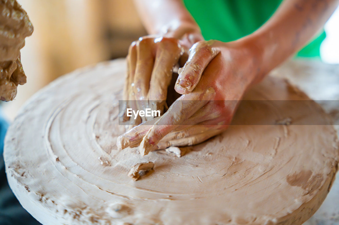 cropped image of man making pottery