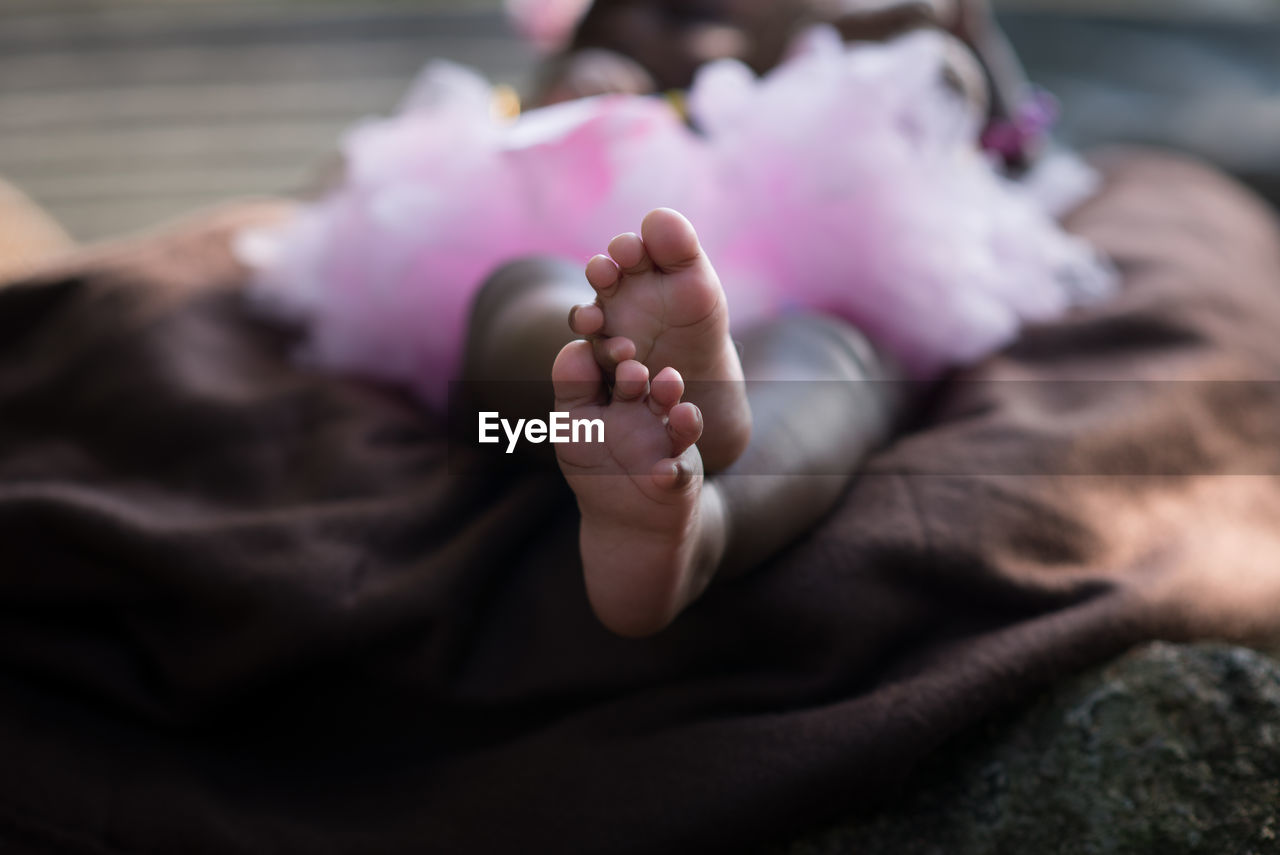 CLOSE-UP OF BABY GIRL SLEEPING ON BED