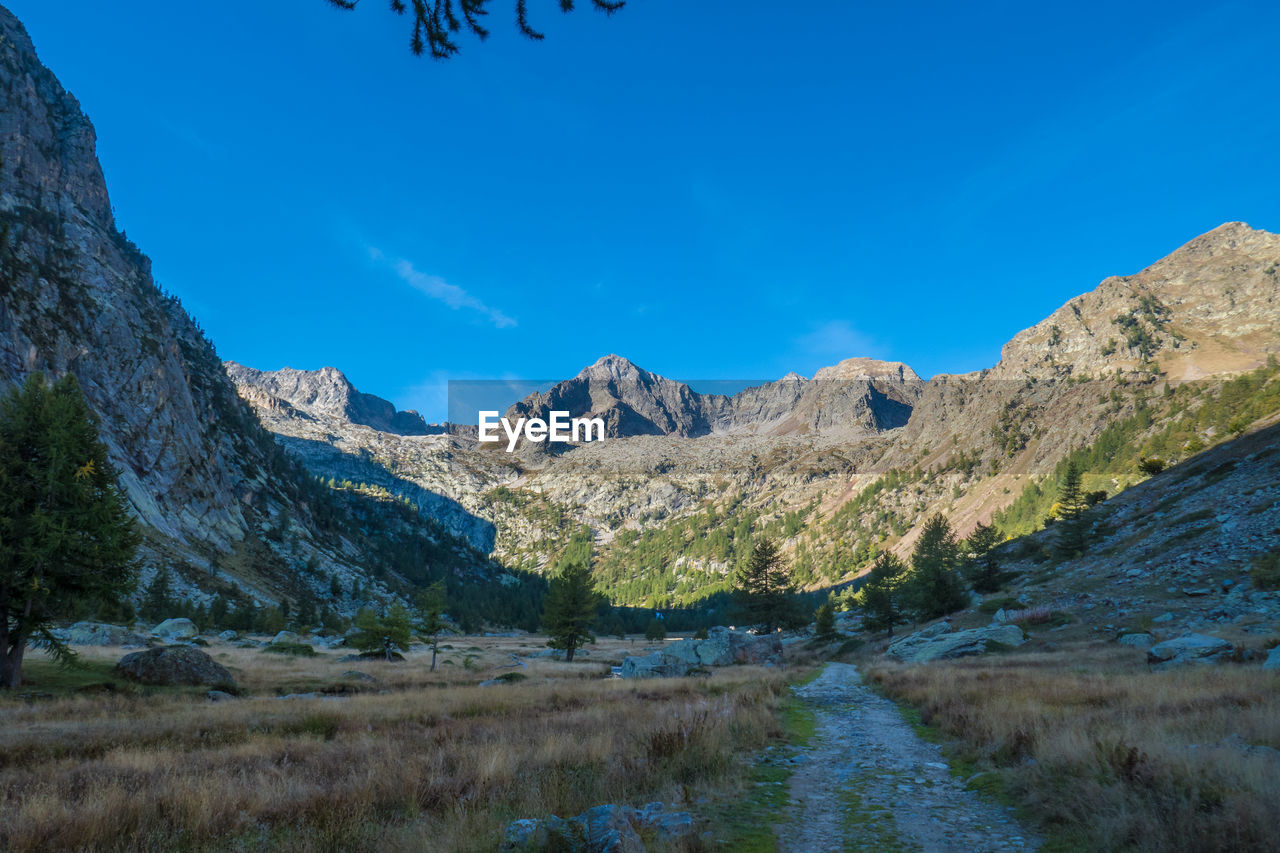 Scenic view of landscape and mountains against blue sky