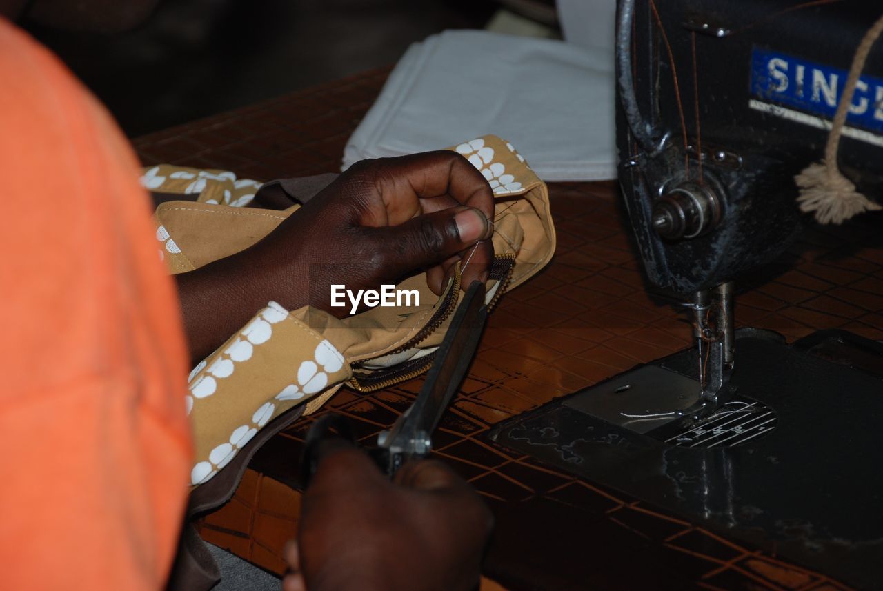 Midsection of woman stitching in workshop