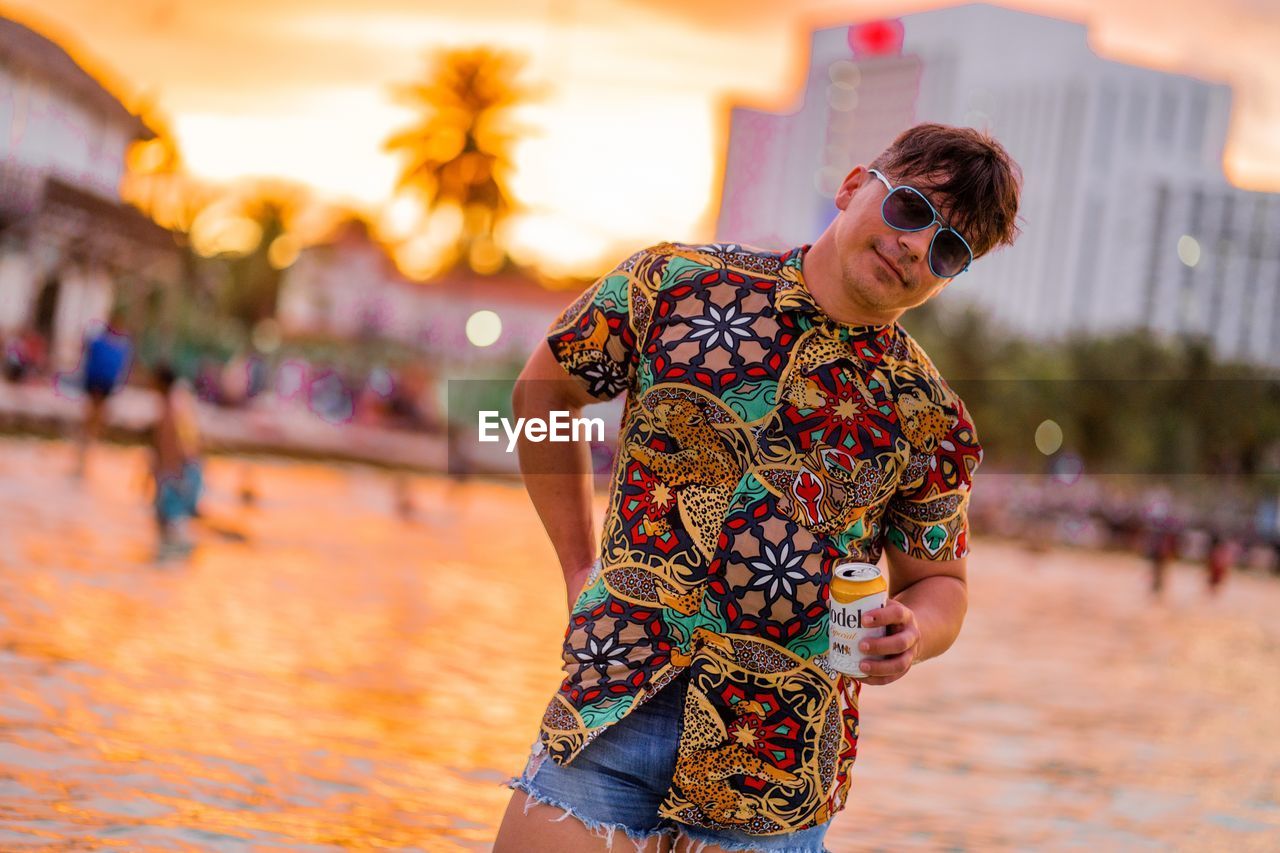 Handsome young man looking at camera with a relaxing bacground view of the beach in cancun, mexico.