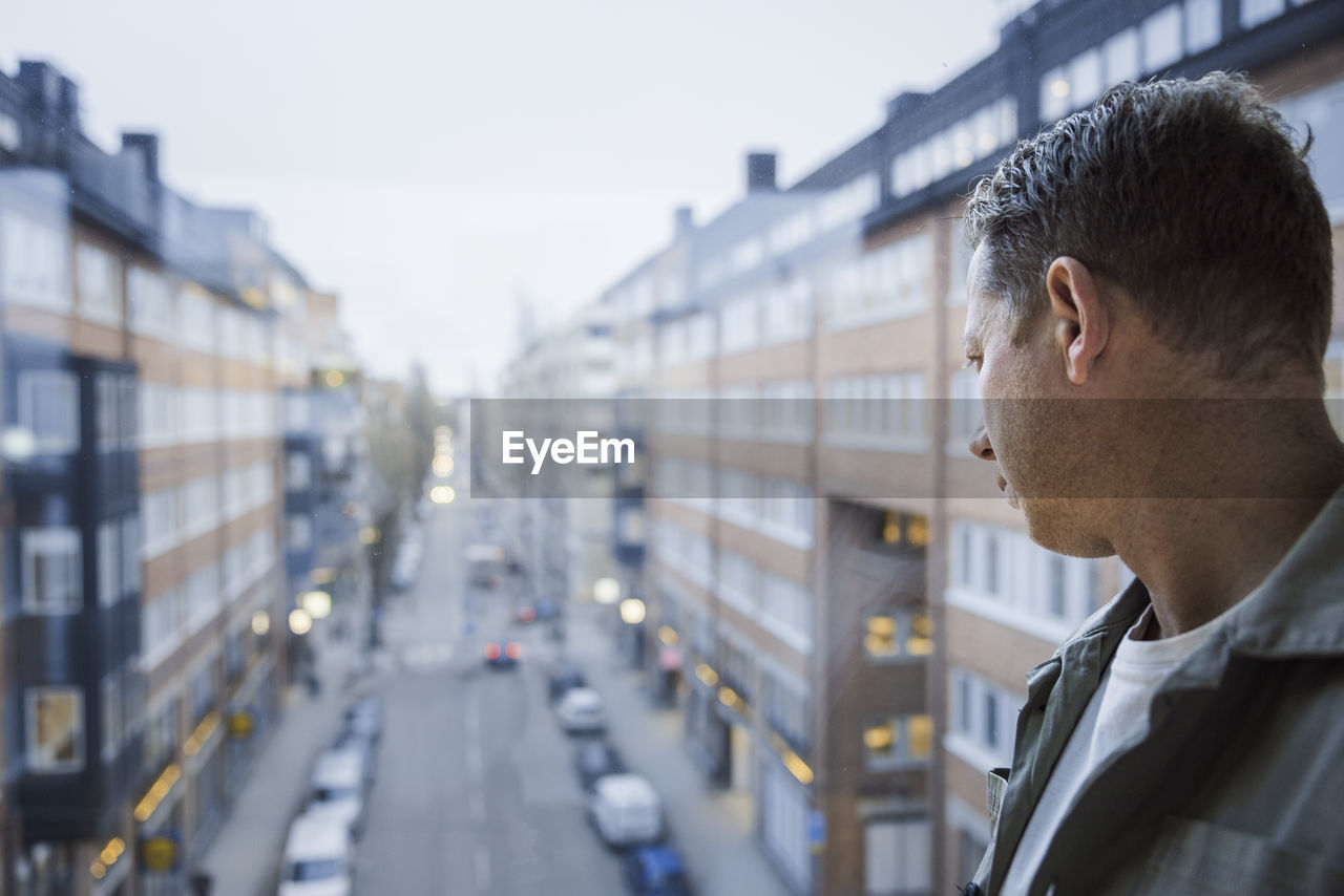 Man looking through window at street