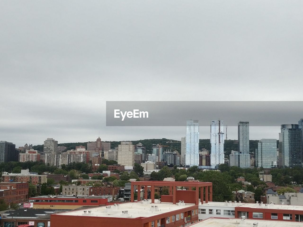 HIGH ANGLE VIEW OF BUILDINGS AND TREES AGAINST SKY