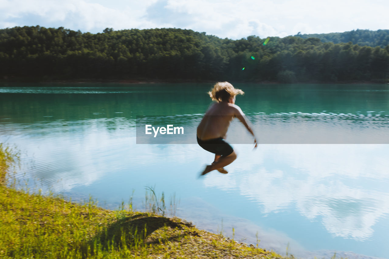 Unrecognizable man falling in lake on sunny day in dolomites in italy