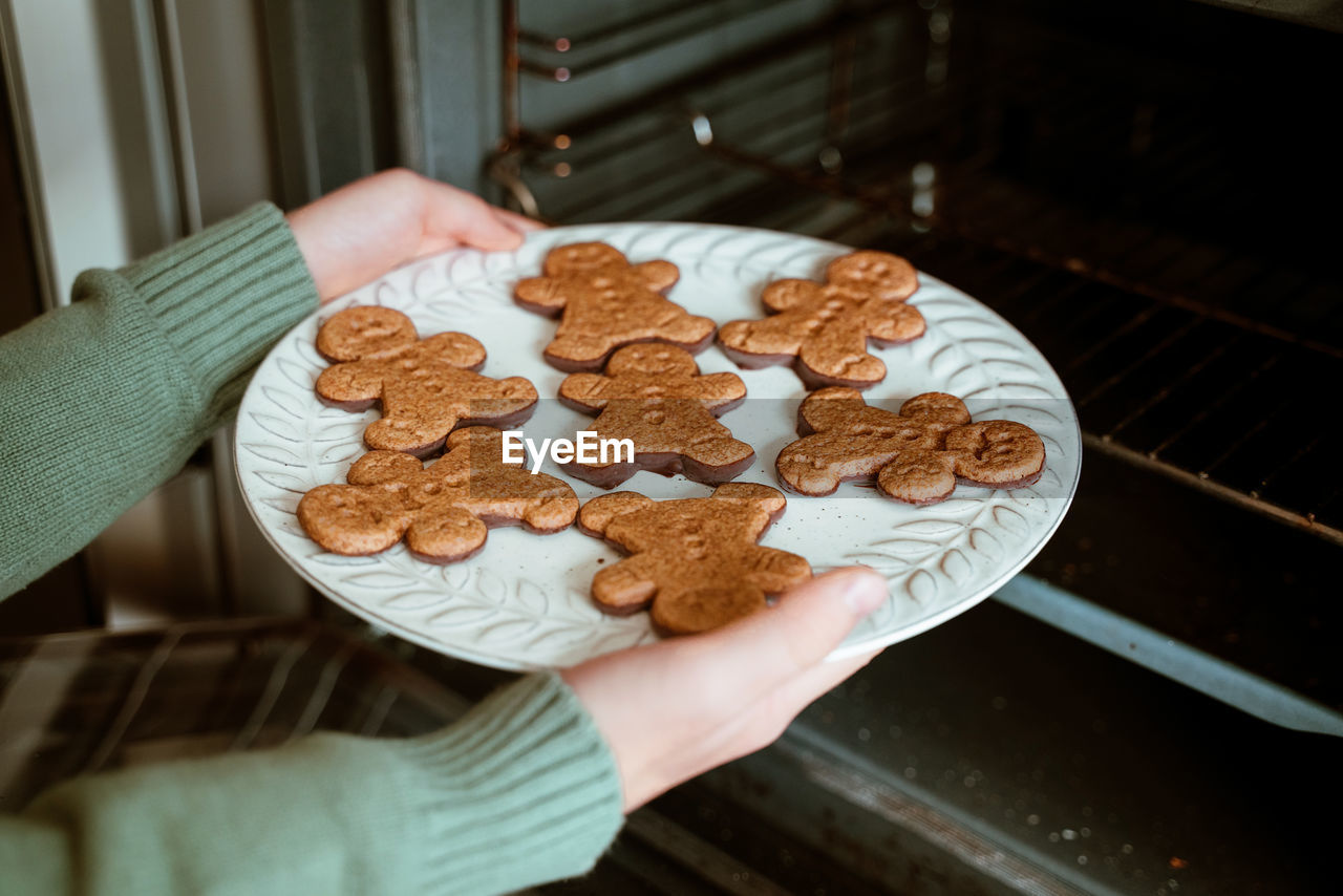 High angle view of woman holding cookies on table